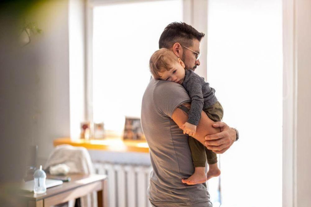 Man holding a young child, relevant to paternity