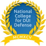 Emblem of the National College for DUI Defense founded in 1995, featuring laurel leaves and a blue background.