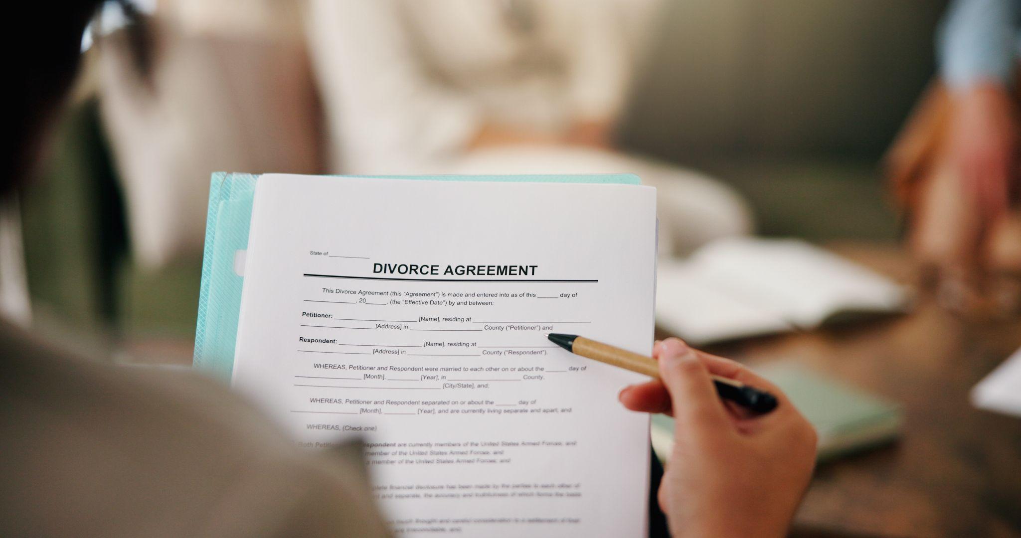 Person holds a pen over family law documents