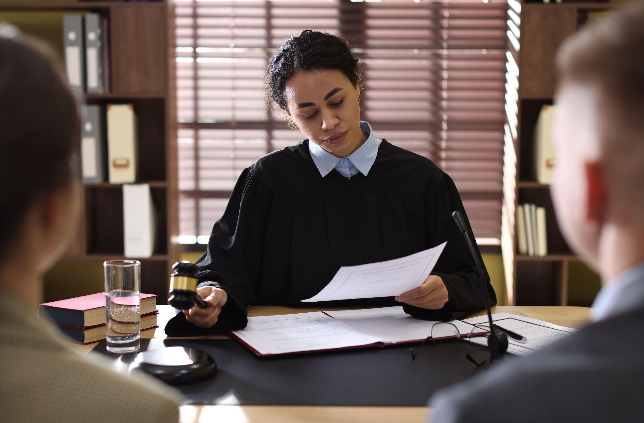 Woman at a desk with a judge discussing