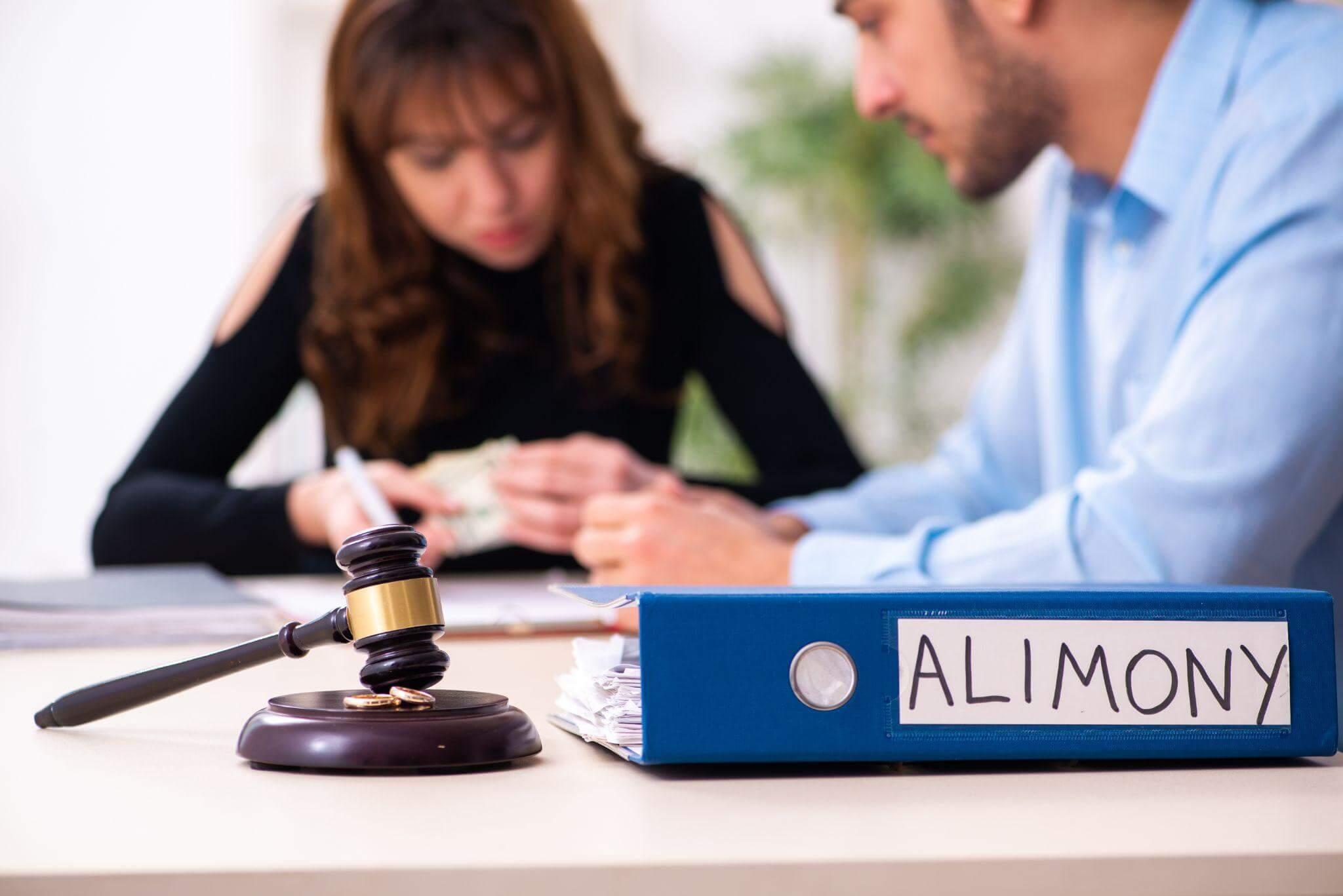 Man and woman with a gavel discussing alimony with