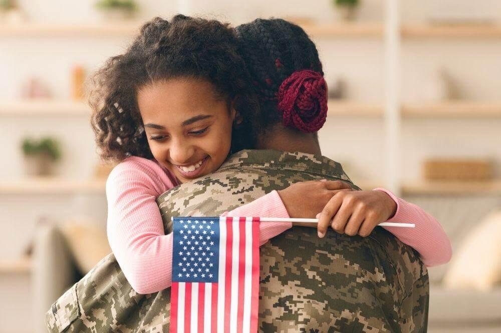 Woman hugging a soldier holding a flag