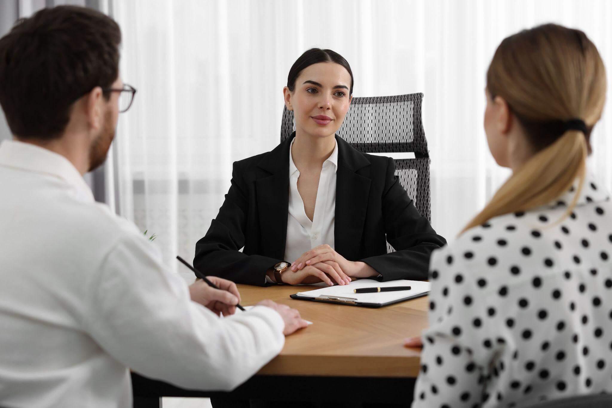 Woman client talking with two attorneys at a table