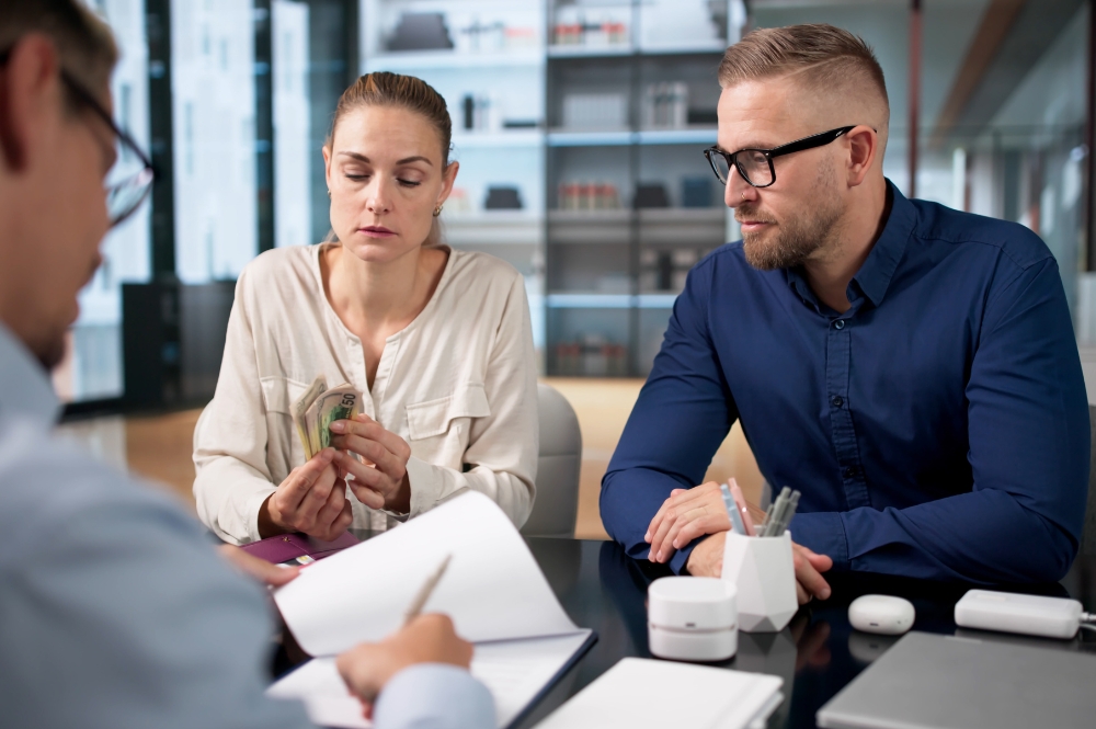 A man and woman discussing child support modification details with a lawyer. | Horak Law A man and woman discussing child support modification details with a lawyer.